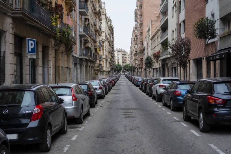 Calle urbana con fila de coches estacionados